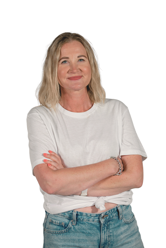 Hymyilevä nainen seisoo taustaa vasten.